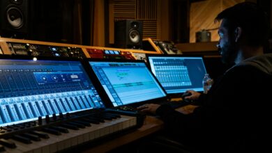 Side view of concentrated young male musician working on computer in studio while composing new song
