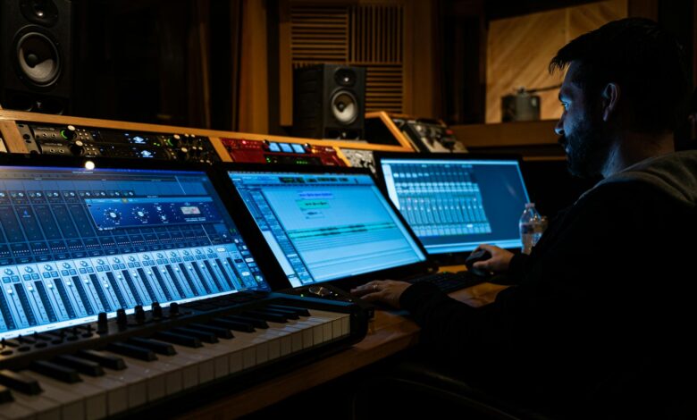 Side view of concentrated young male musician working on computer in studio while composing new song