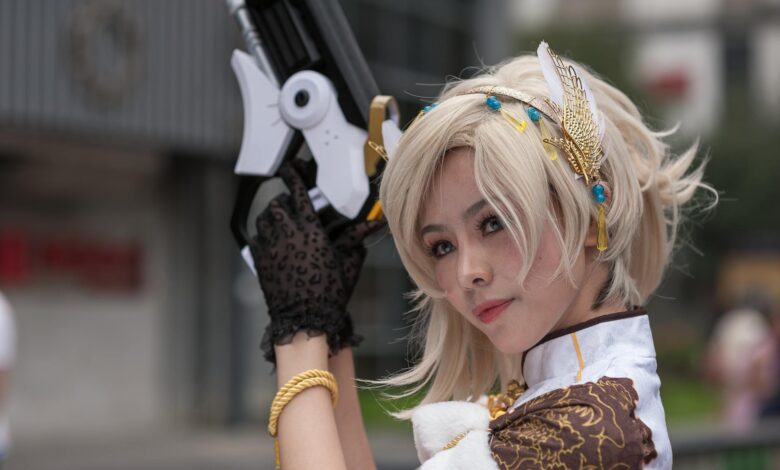 Cosplayer with intricate costume and prop gun, posing outdoors during the day.