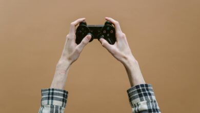 Close-up of hands holding a game controller against a brown background, perfect for gaming themes.
