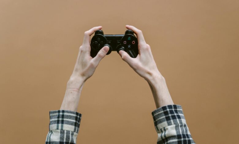 Close-up of hands holding a game controller against a brown background, perfect for gaming themes.