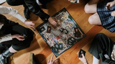 Aerial view of friends enjoying a board game on wooden floor.
