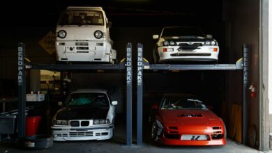 A collection of modified sports cars on a mechanical garage lift in Compton, CA.