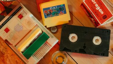 Vintage gaming console with cartridges and VHS tape on wooden surface, nostalgic theme.
