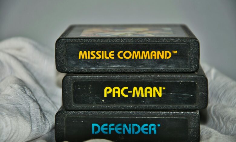 Close-up of vintage Atari game cartridges for Missile Command, Pac-Man, and Defender.