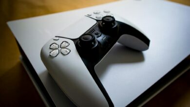 Detailed shot of a PlayStation 5 controller resting on the console, highlighting modern gaming design.