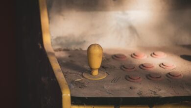 Close-up of a dusty vintage arcade machine control panel with joystick and buttons, evoking nostalgia.