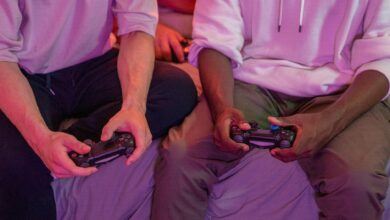 Two friends playing video games together at home, using controllers.