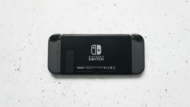 A close-up of a Nintendo Switch console placed on a textured marble surface, highlighting the device's sleek design.