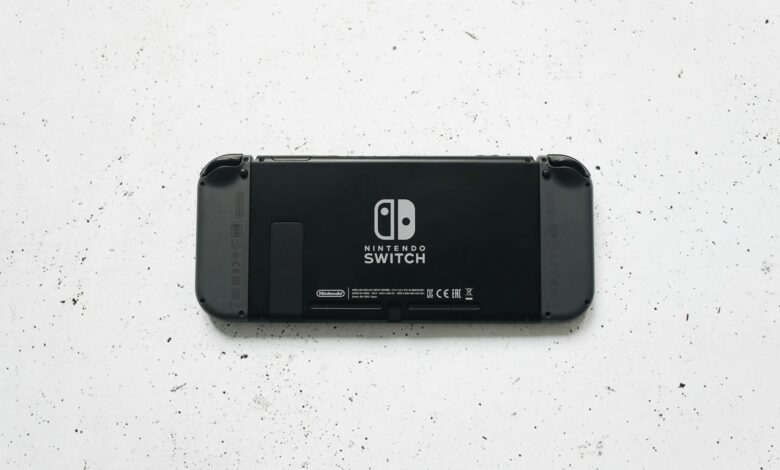 A close-up of a Nintendo Switch console placed on a textured marble surface, highlighting the device's sleek design.