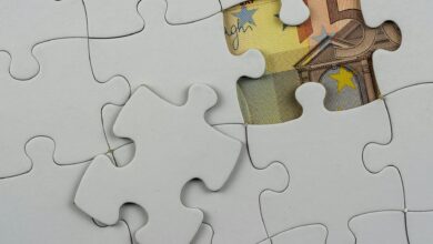 Close-up of a jigsaw puzzle missing piece revealing Euro currency underneath.
