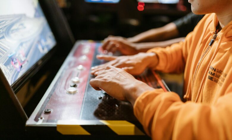 Close-up of hands at an arcade machine. Engaging in gaming, technology and recreation.