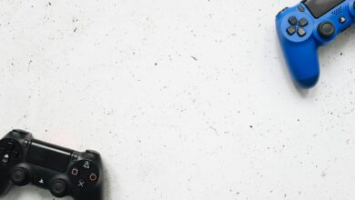 Top view of black and blue game controllers on a white surface.