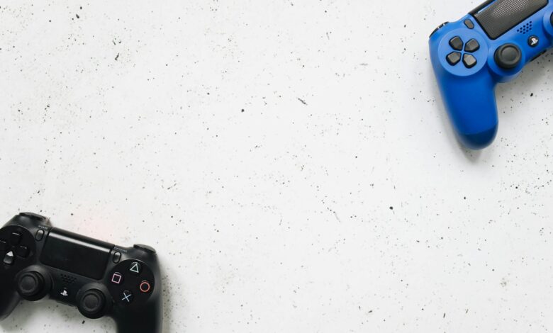 Top view of black and blue game controllers on a white surface.