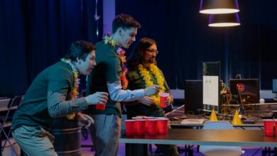 Group of male colleagues enjoying a fun beer pong game during an office party night.