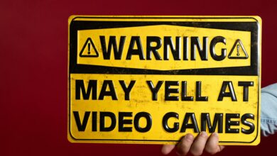 Yellow warning sign humorously cautioning about potential yelling at video games.