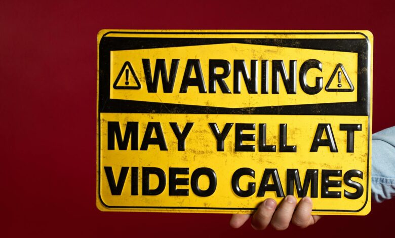 Yellow warning sign humorously cautioning about potential yelling at video games.