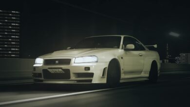 Stunning Nissan GT-R R34 captured driving through Tokyo's highways at night, showcasing its iconic design and headlights.
