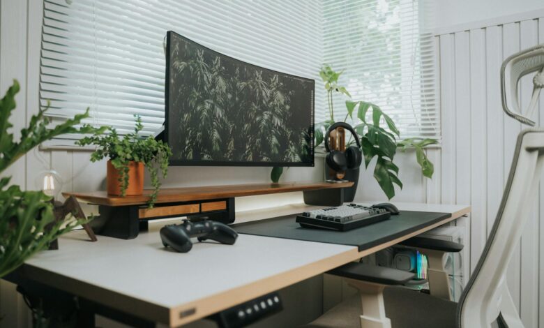 A stylish home office setup with a curved monitor, keyboard, and green plants.