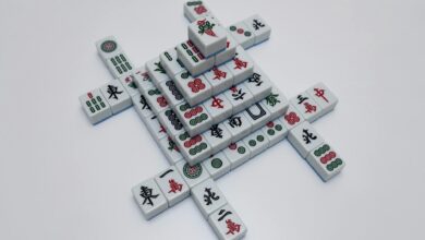 High-angle view of intricately arranged mahjong tiles on a white surface, showcasing traditional symbols.