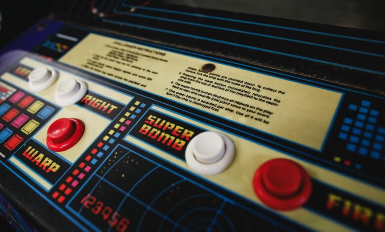 Close-up of a vintage arcade game control panel with colorful buttons and instructions.