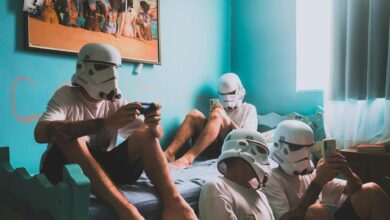 Four friends wearing helmets, playing video games indoors. Modern bedroom vibe.