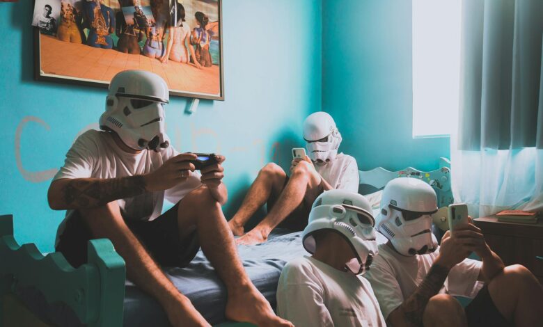 Four friends wearing helmets, playing video games indoors. Modern bedroom vibe.