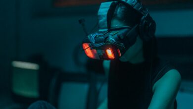 A woman in a dim-lit room wearing a neon-lit VR headset, creating a cyberpunk ambiance.
