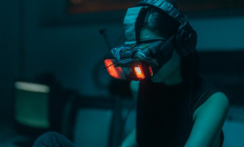 A woman in a dim-lit room wearing a neon-lit VR headset, creating a cyberpunk ambiance.