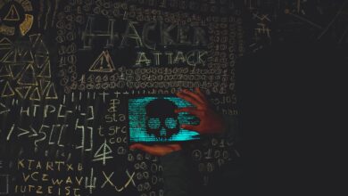 A hacker in a black hoodie using a tablet displaying a skull, surrounded by chalk symbols and 'Hacker Attack' text.