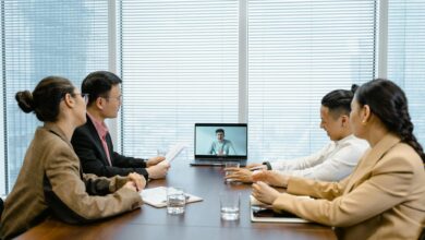 Business meeting with video call setup, highlighting teamwork and communication in a modern office environment.