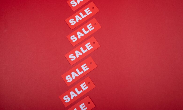 Red sale tags aligned diagonally on a red background, perfect for retail promotions.
