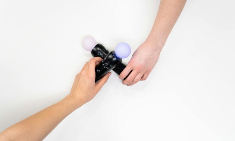 Two hands holding a black gaming controller with glowing spheres, flat lay.