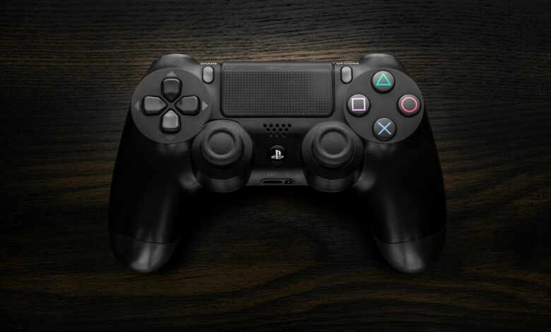 High-resolution image of a Sony DualShock 4 game controller against a dark wooden background.