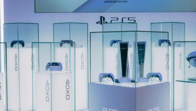 PlayStation 5 consoles and accessories on display in a sleek, futuristic showroom.