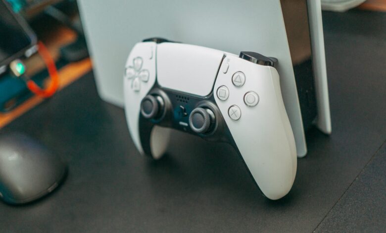 Close-up of a PlayStation 5 controller resting on its console, showcasing modern gaming technology.