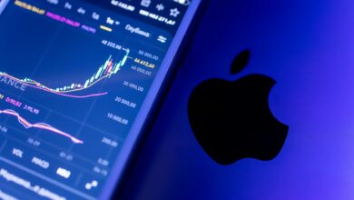 A close-up of an Apple device displaying stock market graphs, indicating economic trends.