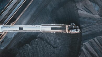 Top view of black coal moving on modern conveyor belts in industrial area in daytime