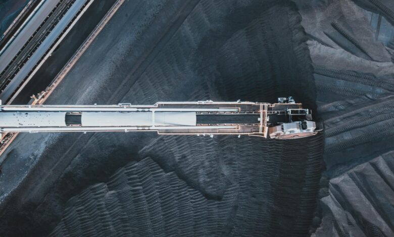 Top view of black coal moving on modern conveyor belts in industrial area in daytime