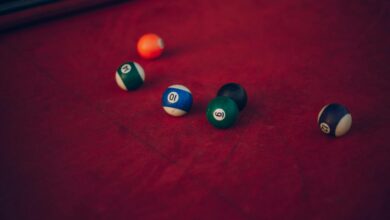 Vibrant billiard balls scattered across a red pool table, ready for a new game.