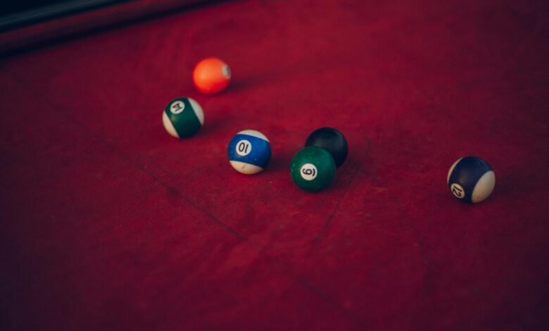 Vibrant billiard balls scattered across a red pool table, ready for a new game.