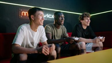Three friends enjoy gaming together indoors, smiling and engaged with controllers.