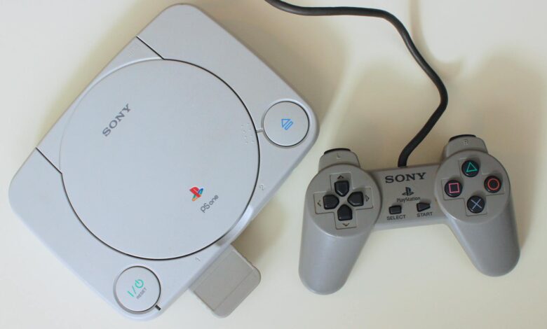 Close-up view of a retro Sony PlayStation One console with controller, ideal for game nostalgia enthusiasts.
