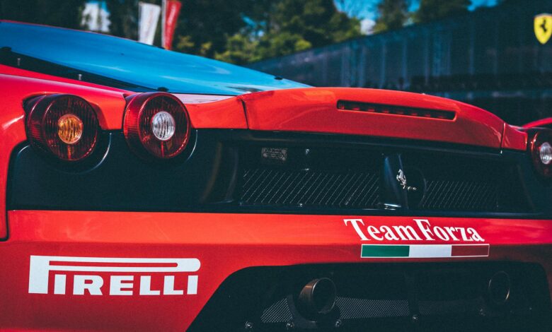 Racing car with Pirelli branding, featuring aerodynamic rear designs. Captured in daylight outdoors.