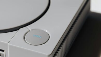 Detailed shot of a classic Sony PlayStation, highlighting the iconic open button and retro design.