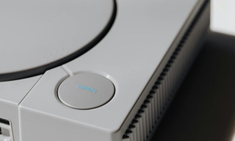 Detailed shot of a classic Sony PlayStation, highlighting the iconic open button and retro design.