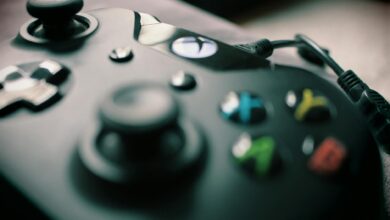 Detailed view of a black gaming controller showcasing its sleek design and colorful buttons.
