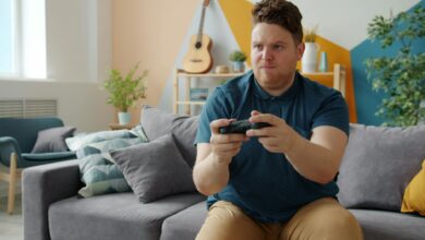 Focused young man enjoying gaming at home with a console in a stylish living room.