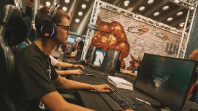 A young male gamer intensely focused during an esports event at an indoor gaming convention.