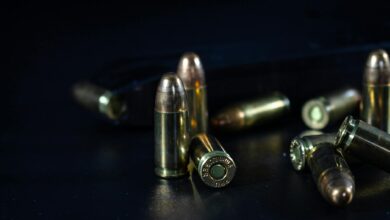 Detailed macro shot of bullets lying on a dark surface, emphasizing texture and shine.